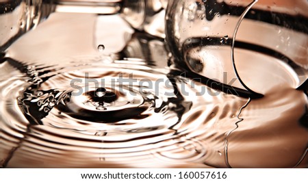 Closeup Orange Water drops and Beverage glass in pool.