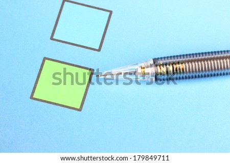 Closeup Mechanical pencil point to Green Check box on blue background.