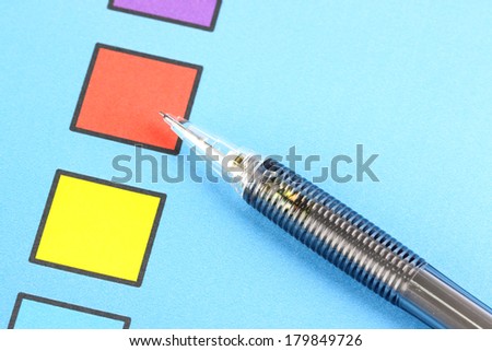Closeup Mechanical pencil point to Red Check box on blue background.