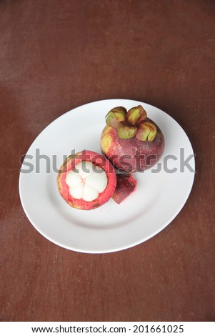 Fresh mangosteen fruit of peeling in dish on the foods table.