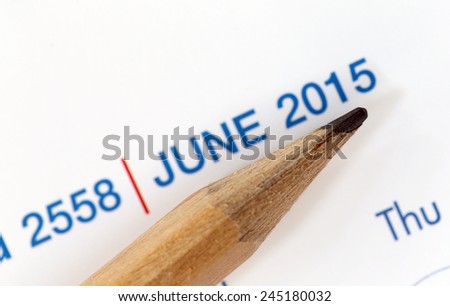 The tip of a pencil point to the year 2015 blur Text on a calendar.
