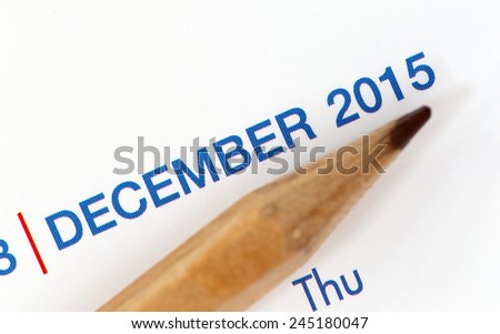 The tip of a pencil point to the year 2015 blur Text on a calendar.
