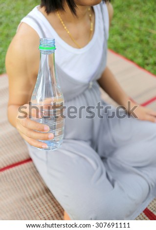 Pregnant women have a water bottle in hand to drink more water to the health of the baby.