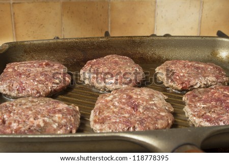 raw burgers on a griddle