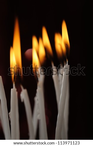 Candles made from white wax firing on the black background.