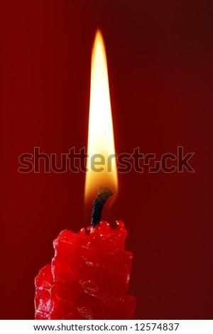 Red candle on the red background.