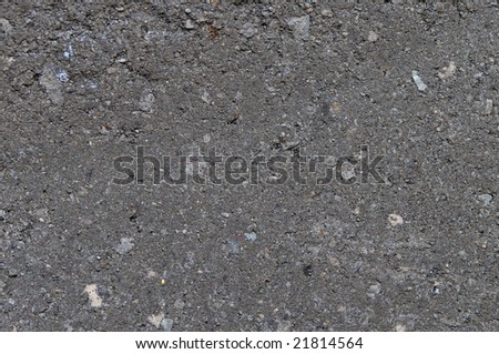 Dark grey concrete with small stones. Old and dusty. Texture.