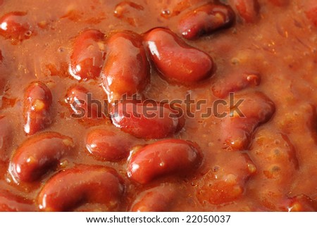 Red beans in the chili sauce fry on the skillet. Narrow depth of field.