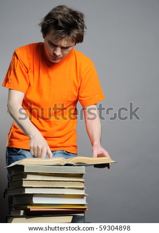 Man with big pile of old big books.