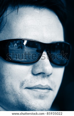 Man on the street in sunglasses. Close-up. Blue tint.