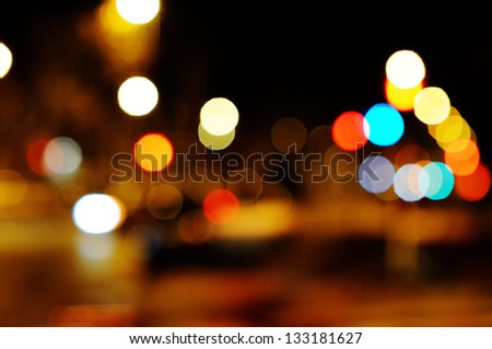 Bright circles from streetlamps on defocused photo of night street.