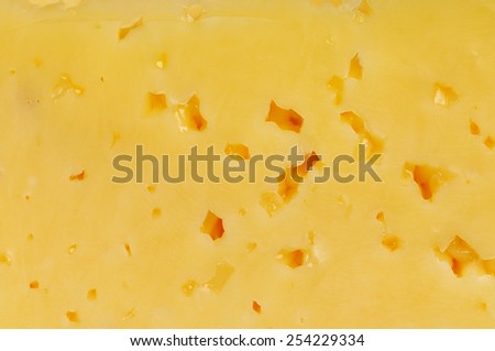 Two thin pieces of cheese on the yellow plate. Texture.