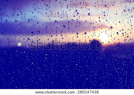 Beautiful sunset after rainy day. View trough the window glass. Defocused.