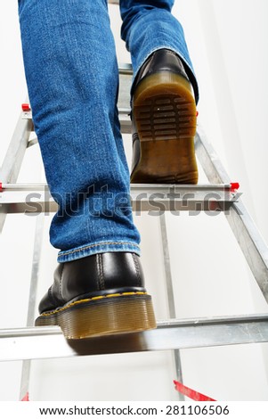 Man on ladder. Closeup. Only his feet in the picture.