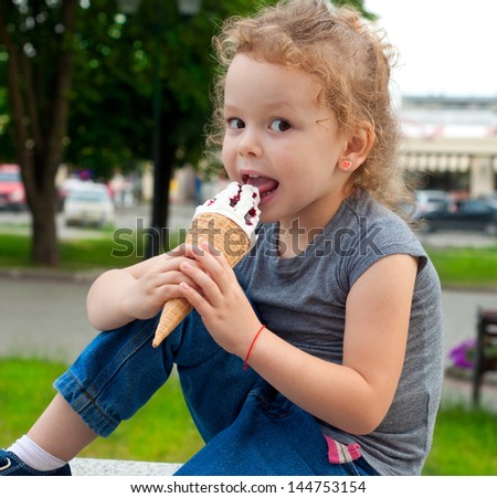 Happy girl with ice cream outdoors
