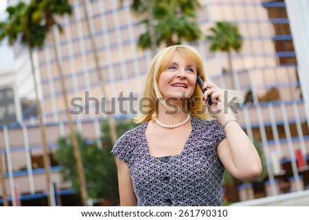 Close Up portrait happy smiling old business woman 60 years in the downtown talking with mobile phone, Lifestyle woman on phone, Business concept - business woman calling on the phone in street