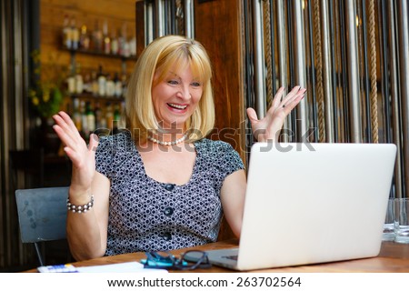 Business woman with laptop, Old senior woman with smile and surprised emotion on face, looking to computer laptop sitting in summer cafe