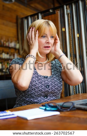 Business woman with laptop, Old senior woman with surprised emotion on face, looking to computer laptop sitting in summer cafe