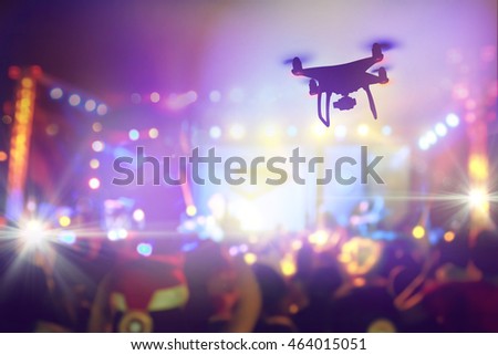 Drone silhouette flying above live concert, Taking photo of concert stage, music festival, happy youth, luxury party, landscape exterior. facebook live. shooting photo and video with drone flying.