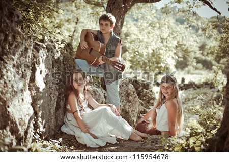 boy playing the guitar, singing girls, hippie style, vintage treatment, style
