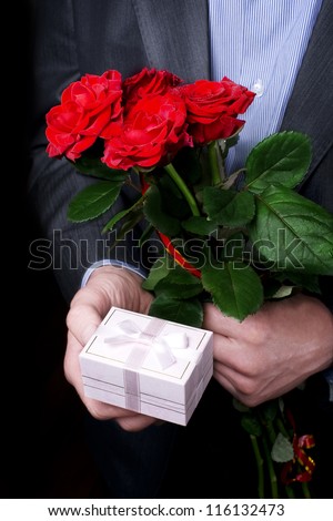 man gives a box packaging for jewelry and red rose