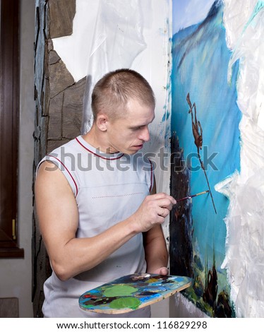 artist paints oil painting on the wall
