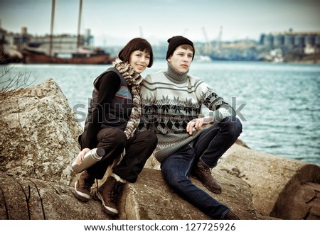 Tourists drink tea by the sea and lakes. Beautiful young couple relaxing on the beach