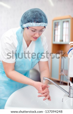 Beautiful nurse, washes his hands before the procedure,wiped his hands dry.Surgical hand washing. The doctor washes his hands for surgery