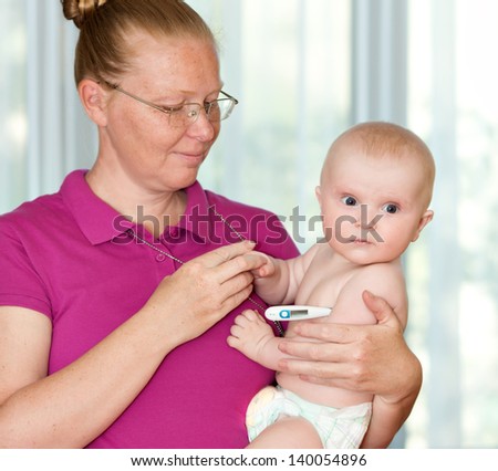 mother measures the temperature of a child. child care.
