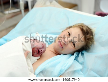 woman with a newborn baby. birth in hospital. baby after birth. child one day old