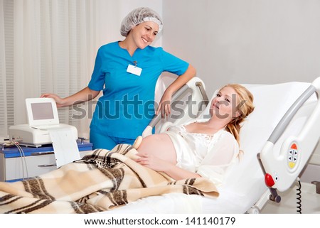 screening of pregnant women in the hospital. doctor examines a pregnant woman to the hospital, auscultation of fetal newborn