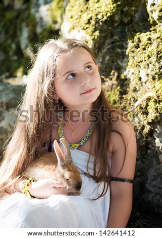 Boy and girl playing with pet rabbit. Girl walking in the park
