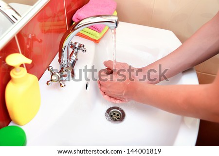 washing hands in bathroom.Wash basin with mixer tap and towels