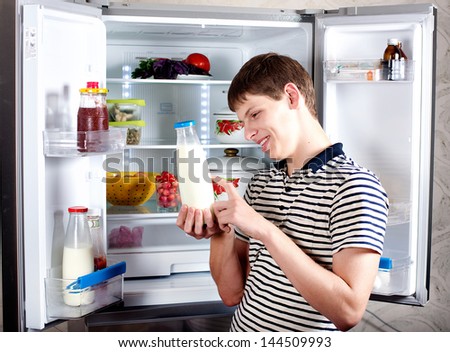 Attractive man looking for something in the fridge at home. Hungry young man opens the refrigerator. The food in the refrigerator.