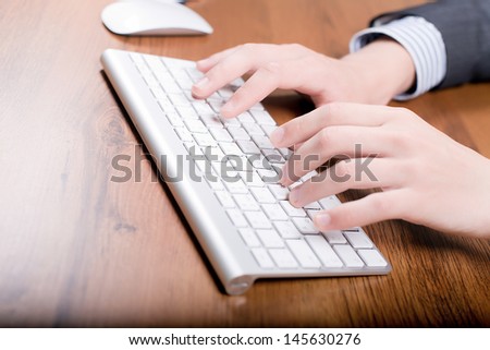 Businessman writing in notebook. Very slim keyboard for your compute. Working on computer