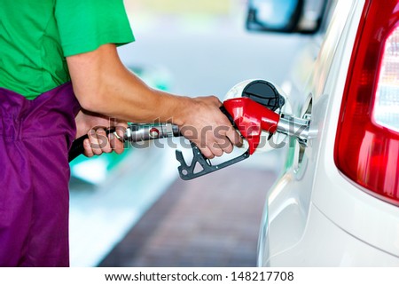 To fill the machine with fuel. Mashunya fill with gasoline at a gas station. Gas station pump. Man filling gasoline fuel in car holding nozzle. Close up.