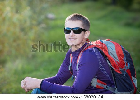 tourist with a backpack in the mountains. Hikers with backpacks enjoying valley view from top of a mountain.