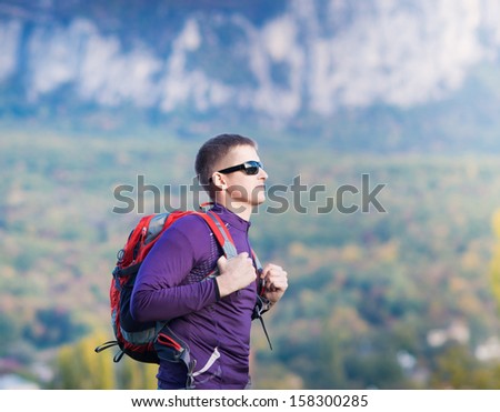 tourist with a backpack in the mountains. Hikers with backpacks enjoying valley view from top of a mountain.