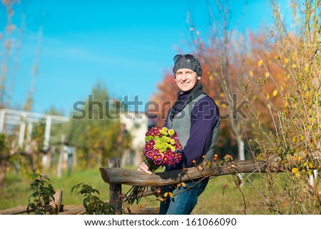 Beautiful  elegant man in a park in autumn. Man with flowers