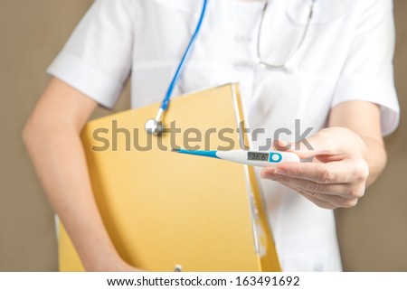 female doctor measures the temperature of the patient.  Measurement of body temperature