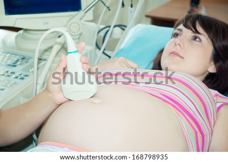 Ultrasound examination of the pregnant woman thirty weeks. Pregnant woman in hospital.