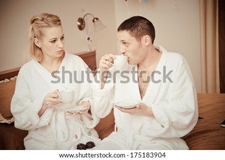 Man and woman drinking coffee in the morning in bed. Young lovers lay in bed