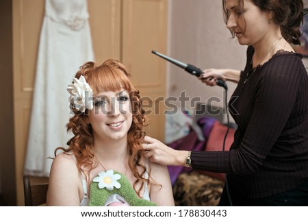 Young beautiful bride applying wedding make-up by make-up artists. make-up