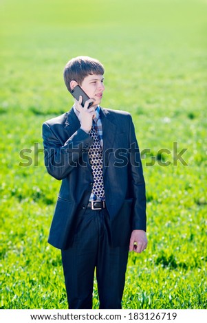 happy young man speaks on a mobile phone outdoors