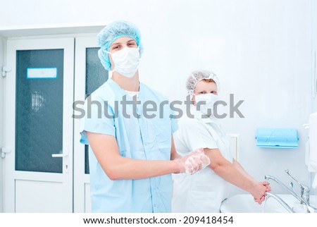 Medical staff sterilizing hands and arms before surgery