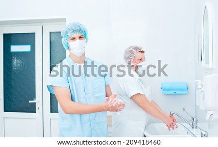 Medical staff sterilizing hands and arms before surgery