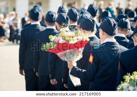 cadet school students on the parade with a bouquet of flowers