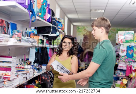 young man buys books and notebooks in the shop