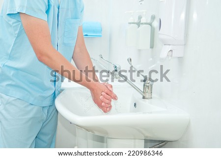 Male surgeon washes his hands before the operation