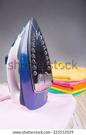 Steam iron and  with clothes, on bright background